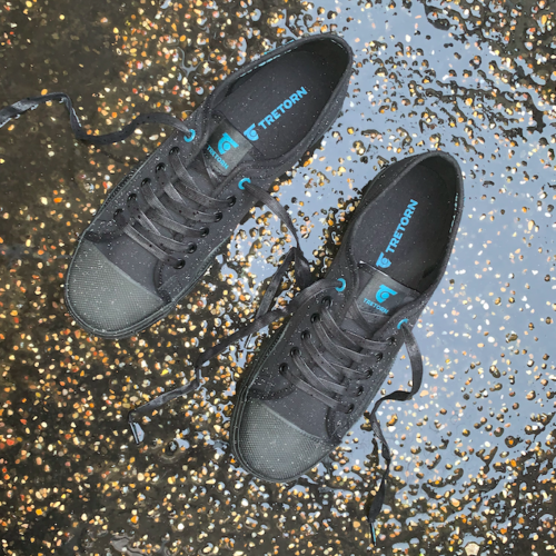 Ett par svarta sneakers i regn